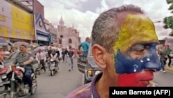 Un trabajador en Caracas en medio de una protesta (AFP/Juan Barreto).