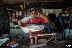 Un hombre despacha arroz en una bodega de San Luis en Santiago de Cuba.