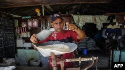 Un hombre despacha arroz en una bodega de San Luis en Santiago de Cuba.