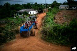 En esta fotografía del 24 de agosto de 2019, un tractor jala un remolque que fue convertido en una piscina a lo largo de las calles del vecindario de El Infernal, en la provincia de Pinar del Río, Cuba. (AP Foto/Ramon Espinosa)