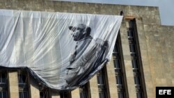 Un obrero despliega un lienzo con la imagen del fallecido líder cubano Fidel Castro en la Plaza de la Revolución .