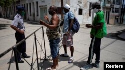 Un policía impide la entrada a un barrio en cuarentena por coronavirus en La Habana. REUTERS/Alexandre Meneghini