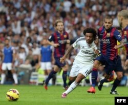 El defensa brasileño del Real Madrid Marcelo Vieira (i) lucha la posición con su compatriota del FC Barcelona Dani Alves.