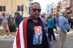 Daniel Llorente se manifiesta envuelto en una bandera estadounidense a la llegada del crucero Adonia a La Habana, en mayo de 2016.