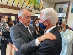 Steve Bovo recibe las condolencias de Johnny López de la Cruz (der.) en el funeral de Esteban Bovo en el Museo de la Brigada 2506 en Miami Lakes.