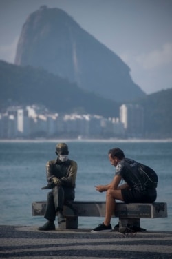 Alguien le puso un nasobuco el martes a la estatua del poeta Carlos Drummond de Andrade en la playa de Copacabana, en Río de Janeiro (Mauro Pimentel/AFP).