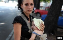 Una mujer carga a su pequeño hijo en La Habana, agosto de 2014.