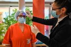 Una enfermera dedicada a casos avanzados de Covid-19 espera el miércoles que le tomen la temperatura en la unidad de cuidados intensivos del hospital Casal Palocco, cerca de Roma (Foto: Andreas Solaro/AFP).