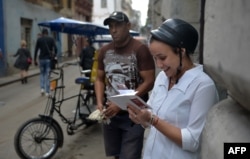 Una mujer se conecta a Internet desde su celular en una calle de La Habana.