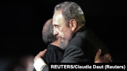 Fidel Castro y Silvio Rodríguez se abrazan tras un concierto del trovador, celebrado en La Habana el 22 de julio de 2004. REUTERS/Claudia Daut