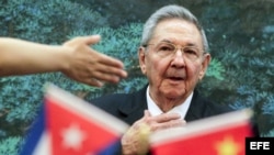 Raúl Castro durante un viaje a China, mientras ondea banderitas de Cuba y el país asiático.