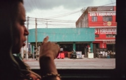 Liset señala por la ventana de un autobús mientras se dirige a la ciudad de Guatemala. (Fotografía de Lisette Poole. Screenshot: NPR)