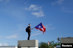 Un hombre ondea la bandera de Puerto Rico durante la protesta de este lunes contra Rosselló.