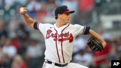 Kyle Wright, abridor de los Bravos de Atlanta, lanza en contra de los Rockies de Colorado en la primera entrada del juego de béisbol del miércoles 31 de agosto de 2022, en Atlanta. Wright llegó a 17 victorias, líder de las Grandes Ligas. (AP Foto/Hakim Wright Sr.)