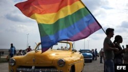 Un grupo de personas sostiene una bandera de la comunidad LGTBI durante una "conga" contra la homofobia y la transfobia en La Habana.