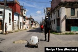 Un hombre tira una carriola con galones de agua que brinda un grupo religioso en La Habana para frenar la escasez del preciado líquido. (REUTERS/Norlys Pérez)