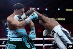 Erislandy Lara golpea a Danny García en la pelea por el título de peso mediano, el sábado 14 de septiembre, en Las Vegas. (Foto AP/John Locher)