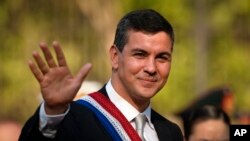 El presidente de Paraguay, Santiago Peña, saluda antes de un desfile militar durante su toma de posesión en Asunción, Paraguay, el martes 15 de agosto de 2023. (AP Photo/Jorge Saenz)