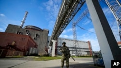 ARCHIVO - Un militar ruso vigila un área de la central nuclear de Zaporizhzhia, en el sureste de Ucrania, el 1 de mayo de 2022. La ONU adoptó una resolución donde exige a Rusia que retire urgentemente a su ejército y su personal de la central nuclear. (Foto AP/Archivo)