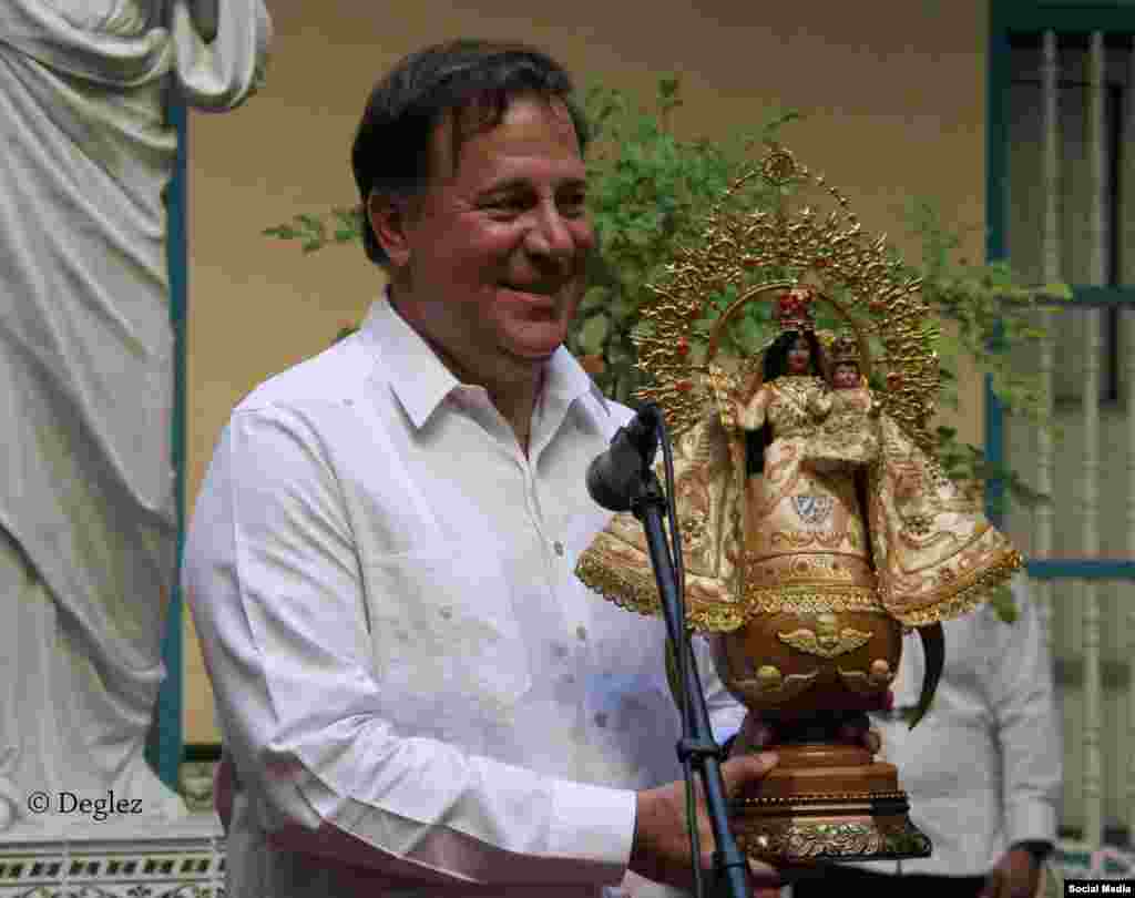 El presidente Varela recibe un estatuilla de la Virgen de la Caridad del Cobre, patrona de Cuba, durante su visita al Arzobispado de La Habana. 