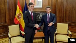 El primer ministro de España, Pedro Sánchez, y el líder de la oposición, Alberto Núñez Feijóo, se dan la mano durante una reunión en el Congreso en Madrid, el 22 de diciembre de 2023. (Foto de OSCAR DEL POZO / AFP)