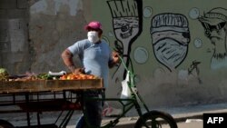 Un vendedor de vegetales en una calle de La Habana usa una máscara para protegerse del coronavirus, el 11 de abril de 2020. (Yamil Lage/AFP)