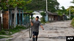 Un hombre camina por una calle antes de la llegada del huracán Rafael a Cuba