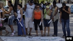 Cubanos observan objetos pertenecientes a pacientes enfermos de sida ya fallecidos. Archivo.