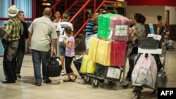 Cubanos hacen fila para chequear en Aduana en el aeropuerto Internacional José Martí de La Habana. (AFP/Adalberto Roque/Archivo)