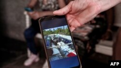 Idalmis Tirado muestra una foto de la balsa en la que naufragó su hijo, Dariel Alejandro Chacón, junto a otros 30 cubanos que zarparon de Cárdenas, Matanzas, en enero de 2023. (Yamil Lage/AFP)