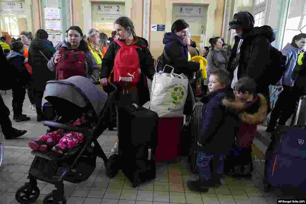 Refugiados con niños esperan ser transportados en una estación de trenes en Przemysl, Polonia. Foto: AP/Sergei Grits.