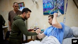 El presidente Volodymyr Zelensky estrecha la mano de un soldado herido durante su visita a un hospital en Kiev, Ucrania. (Oficina Presidencial Ucraniana de Prensa, vía AP)