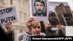 ARCHIVO - Una manifestante sostiene una foto que muestra al presidente ruso Vladimir Putin con los rasgos de Adolf Hitler durante una manifestación contra la invasión rusa de Ucrania, en Skopje, Macedonia del Norte, el 6 de marzo de 2022. Foto: Robert Atanasovski/AFP.