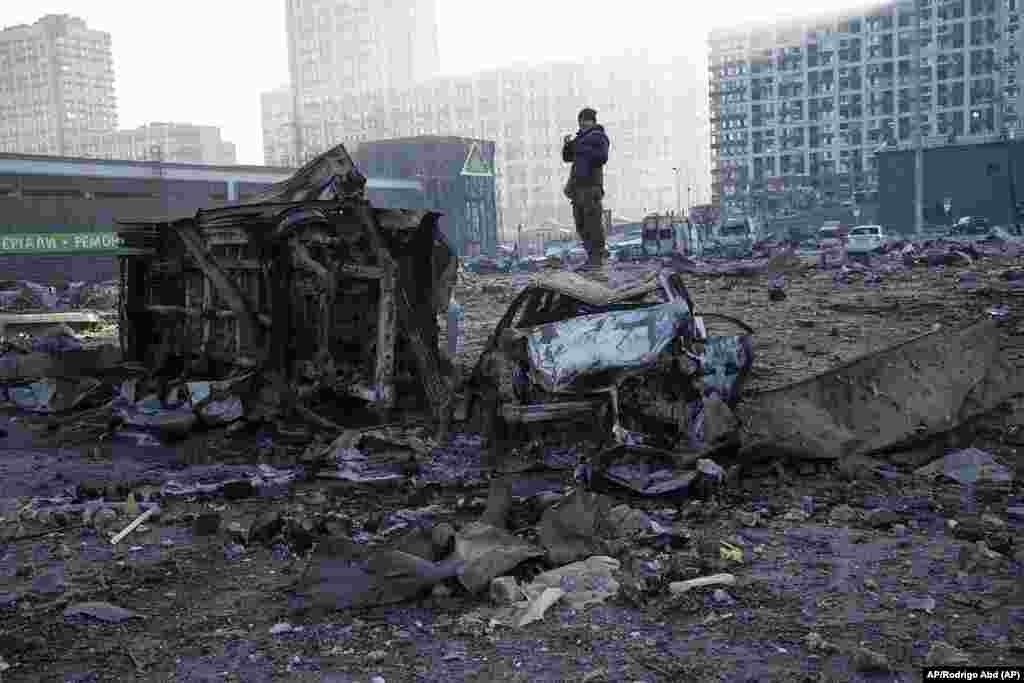 Un hombre se encuentra parado en un carro destruido después de un bombardeo ruso en la capital ucraniana de Kyiv. Foto: AP/Rodrigo Abd.