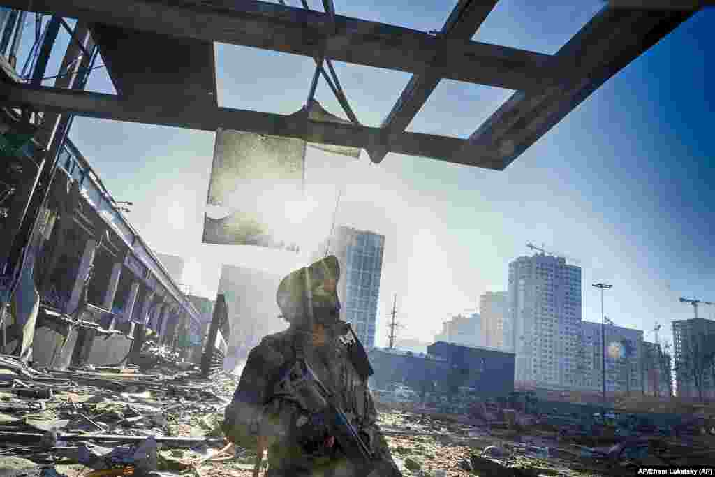 Un soldado ucraniano parado encima de las ruinas que dejó un bombardeo ruso en un centro comercial en Kyiv, Ucrania. Foto: AP/Efrem Lukatsky.