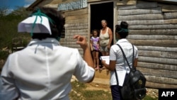 Trabajadores de salud realizan una pesquisa de COVID-19 en un barrio periférico de la localidad de Zaragoza, Mayabeque. (YAMIL LAGE / AFP)