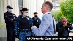 El abogado ruso Ivan Pavlov pasa junto a los agentes de policía para asistir a una sesión del tribunal después de hablar con los medios de comunicación en el Tribunal de Moscú en Moscú, Rusia, el 9 de junio de 2021. Foto: AP/Alexander Zemlianichenko.