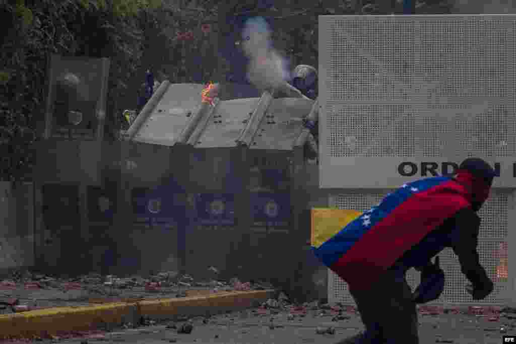 Manifestantes se enfrentan con policías antimotines hoy, jueves 4 de mayo de 2017, en Caracas (Venezuela). Los cuerpos de seguridad dispersaron con gases lacrimógenos la manifestación de estudiantes que se concentró en la Universidad Central de Venezuela 