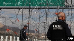 Miembros de la Patrulla Fronteriza de EEUU observan la instalación de las barreras de alambre de púas preparadas para la posible llegada masiva de migrantes al Puente Internacional de Zaragoza, en Ciudad Juárez, estado de Chihuahua, México.