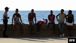 Un policía junto a varios jóvenes en el malecón de La Habana. Foto: Archivo.