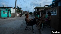 Ls personas se sientan en las afueras de sus casas durante los apagones / Foto: REUTERS/Norlys Perez