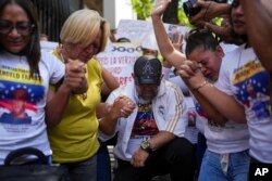 Personas rezan frente a tribunales del Palacio de Justicia por la liberación de los detenidos durante la represión tras las protestas contra los resultados de las elecciones presidenciales, en Caracas, Venezuela, jueves 7 de noviembre de 2024. (AP Photo/Ariana Cubillos)