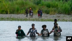 Migrantes haitianos vadean el río Tuquesa, el miércoles 4 de octubre de 2023. Decenas de vuelos chárter que se cree que transportan migrantes que huyen de Haití, han aterrizado en Nicaragua (AP/Arnulfo Franco, File).