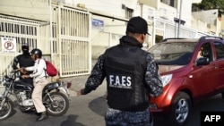 Los miembros de las Fuerzas de Acciones Especiales (FAES) permanecen en un puesto de control en el barrio de los 70 durante una operación policial el 1 de abril de 2019 en Caracas, Venezuela. (STR/AFP).