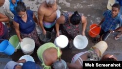 Vecinos hacen cola para abastecerse de agua potable.