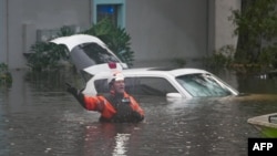 Los socorristas en el agua afuera de un complejo de apartamentos que se inundó y se desbordó un arroyo debido al huracán Milton el 10 de octubre de 2024 en Clearwater, Florida.