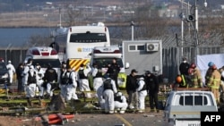 Los equipos de recuperación trabajan en el lugar del accidente de avión en el Aeropuerto Internacional de Muan, a unos 288 kilómetros al suroeste de Seúl