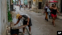 Un cubano cocina con leña en plena calle de La Habana en medio del apagón generalizado que vive la isla. (AP/Ramon Espinosa)