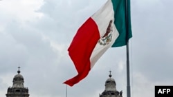 Bandera mexicana ondea fuera de la Catedral Metropolitana de México el 4 de agosto de 2023
