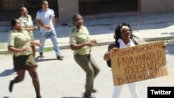 La líder de las Damas de Blanco, Berta Soler, rodeada de represores cuando sale a manifestarse pacíficamente. (Foto: Angel Moya)